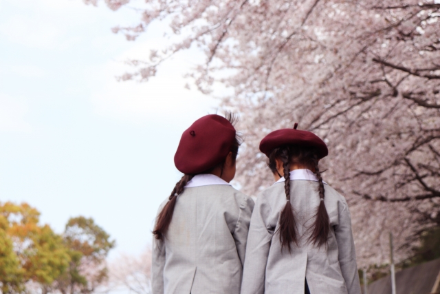 桜の下で姉妹の後ろ姿